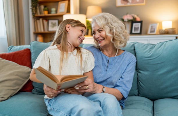 istock Grandmother reading a book to her granddaughter 2183116183