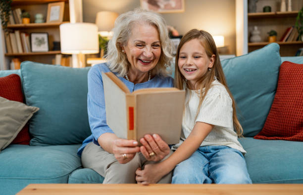 istock Grandmother with granddaughter reading book 2183116833