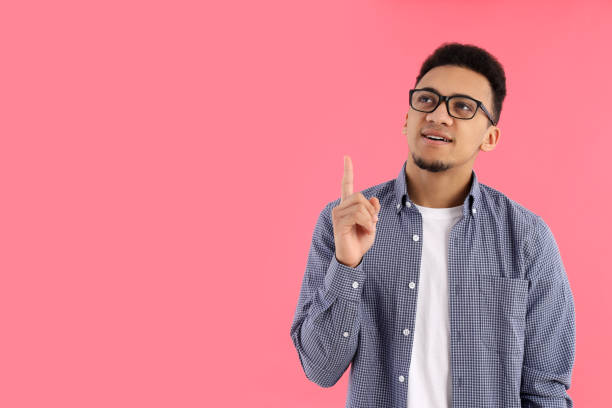 istock Young man in glasses on pink background 2183116925