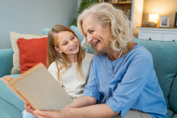 istock Cute granddaughter reading a book with her grandma 2183117183