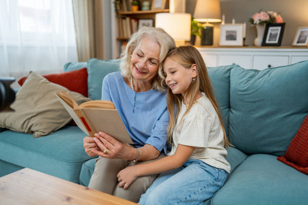 istock Cute granddaughter reading a book with her grandma 2183118009