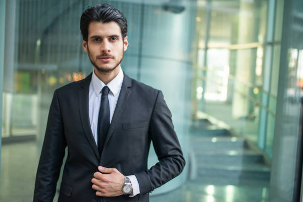 istock Young businessman adjusting his suit in a modern office building 2183118327
