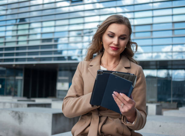 istock Businesswoman using digital tablet outside modern office building 2183120303