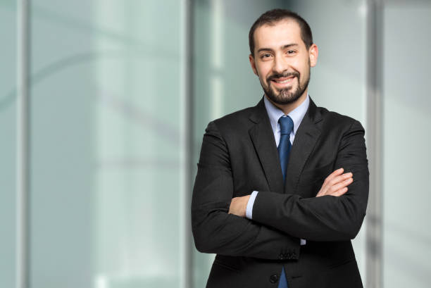 istock Young businessman smiling with arms crossed in office 2183122079