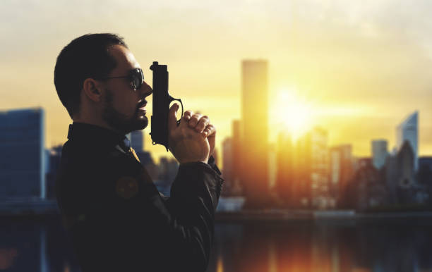 Secret agent holding gun at sunset in city