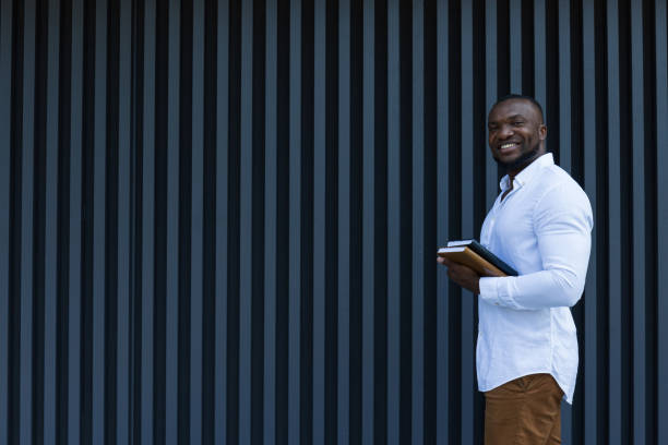 istock A young, successful African-American man with a notebook and a smartphone in his hands 2183125472