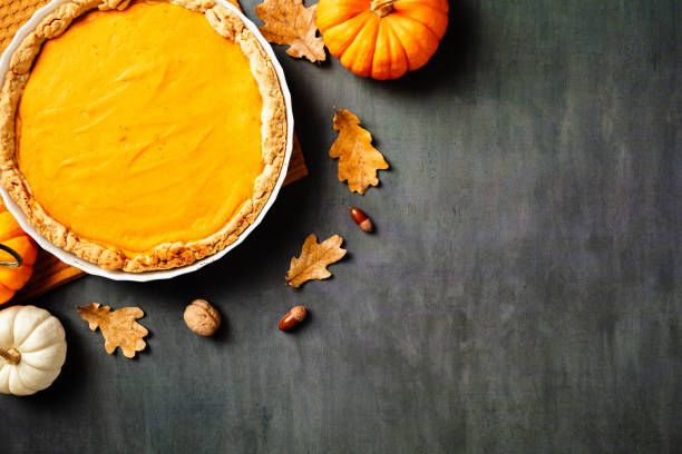istock Flat lay pumpkin pie surrounded by fall leaves and decor. Perfect for seasonal recipes, Thanksgiving, and festive culinary content 2183125986