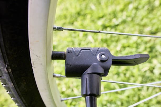 istock Attaching dual head nozzle adapter of air pump to  bicycle valve. 2183133955