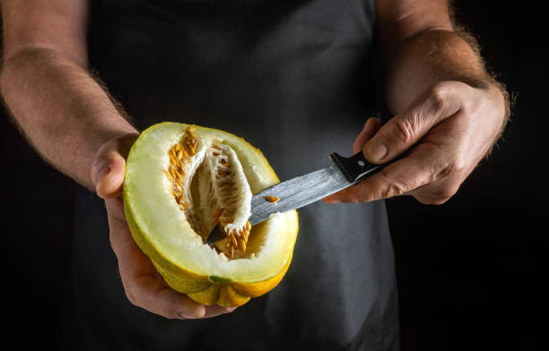 istock A person skillfully cuts into a vibrant melon, revealing its juicy interior while creating a delightful contrast against the dark background of a rustic kitchen 2183134045