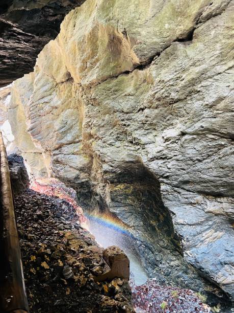 Vibrant rainbow in rocky cavern with sunlight filtering through in Liechtensteinklamm, Austria