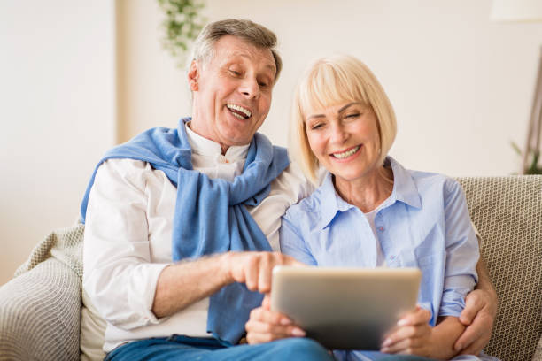 istock Loving senior couple websurfing on laptop computer 2183135123