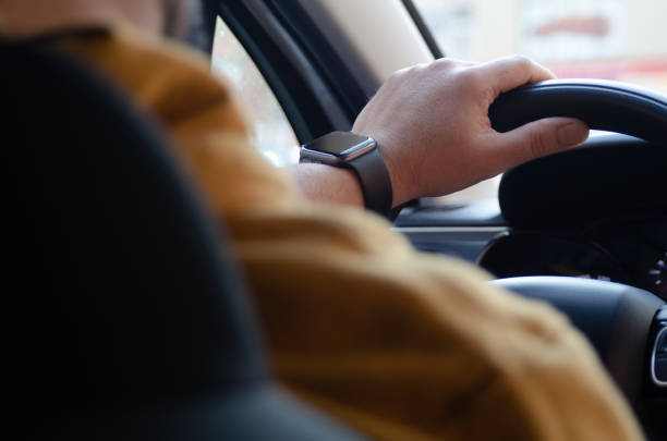 istock Man wearing a smart watch driving a car 2183142530