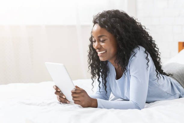 istock Girl reading blog on digital tablet in bed 2183144730