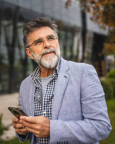 istock senior concentrated man use mobile phone in front modern company 2183145537