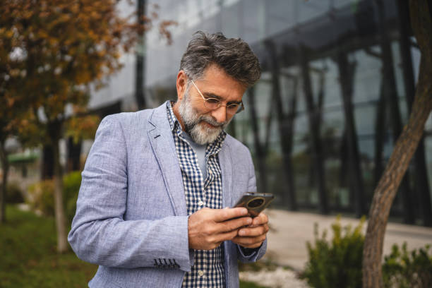 istock senior concentrated man use mobile phone in front modern company 2183146307
