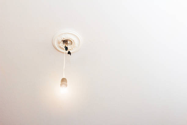istock a lonely light bulb on the ceiling hanging on one wire, a place for copy space 2183147019