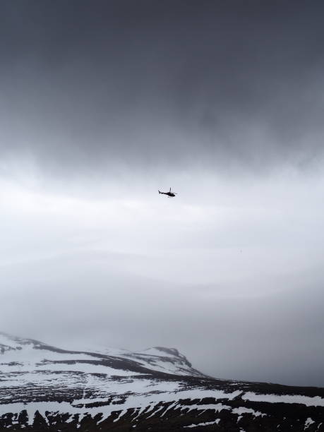 istock A helicopter flies over a rugged snowy mountain landscape under a dark and brooding sky, highlighting a sense of adventure and exploration in a harsh environment. 2183148089
