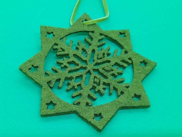 istock One green snowflake shape from textile with green background. 2183151390