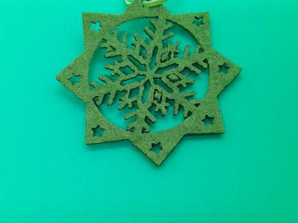 istock One green snowflake shape from textile with green background. 2183151392