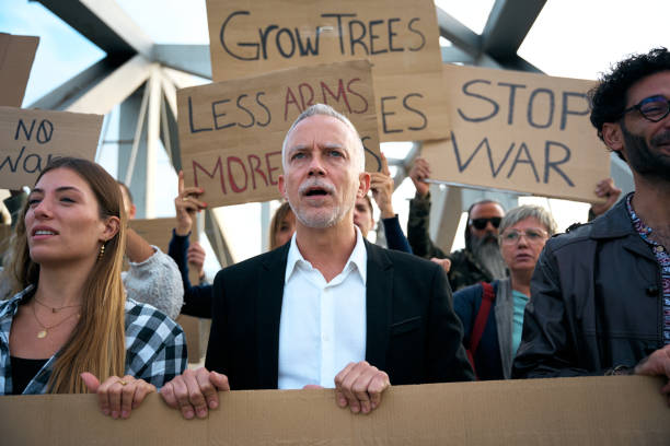 istock Diverse large group of activists in peaceful protest demonstrating together chanting slogans 2183156068