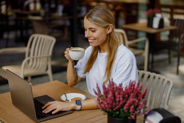 istock Young Woman Working on Laptop in a Cozy Caf Setting 2183156764