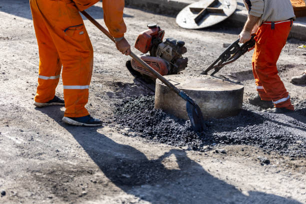 istock Construction workers repairing a road with asphalt in a urban area during daylight hours 2183156920