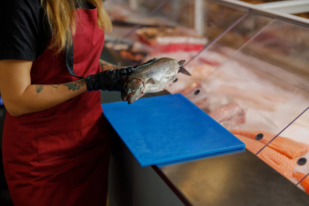 istock A dedicated Fish Shop Worker skillfully preparing fresh and delicious seafood for valued customers 2183157256