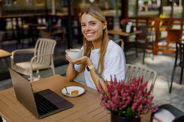 Young Woman Enjoying Coffee at a Caf with Laptop