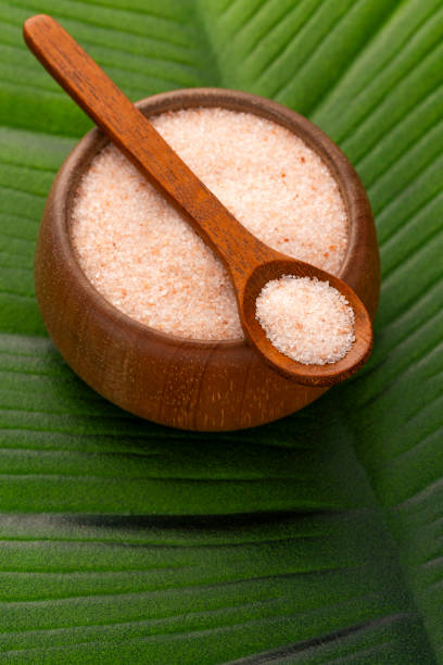 Fine crystals of pink salt in the bowl and spoon - Exotic ingredient for cooking