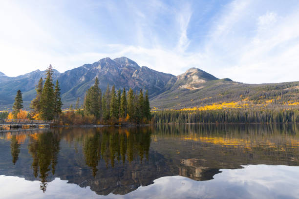 istock Tranquil lake waters at the mountain foot in autumn forest. 2183158243