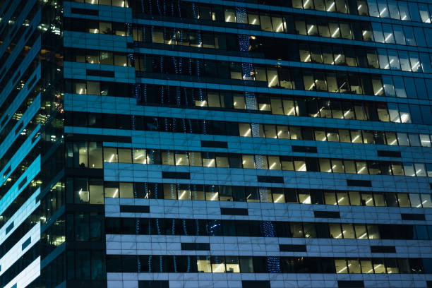 Moscow, Russia - Aug 19 2024: Architectural view of Moscow's Techno City skyscrapers against a deep blue evening sky, showcasing modern glass facades and illuminated windows