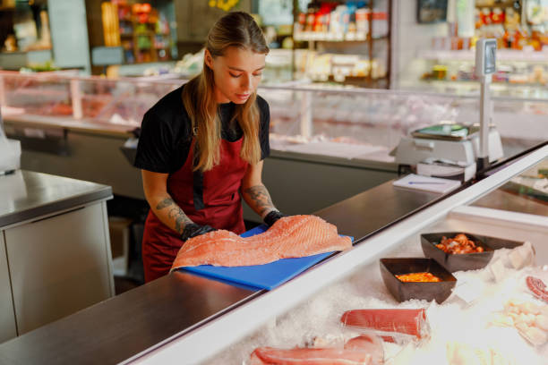 A dedicated fishmonger is skillfully preparing an array of fresh and exquisite seafood delicacies