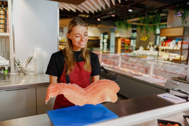 istock A dedicated fishmonger offering exceptionally fresh salmon at a vibrant and lively market 2183159408