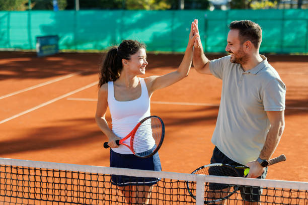 Two tennis players celebrating with a high five.