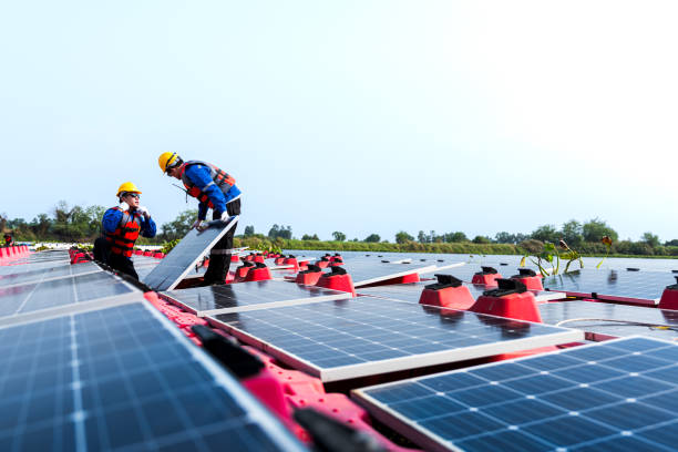 istock Male workers repair Floating solar panels on water lake. Engineers construct on site Floating solar panels at sun light. clean energy for future living. Industrial Renewable energy of green power. 2183165598