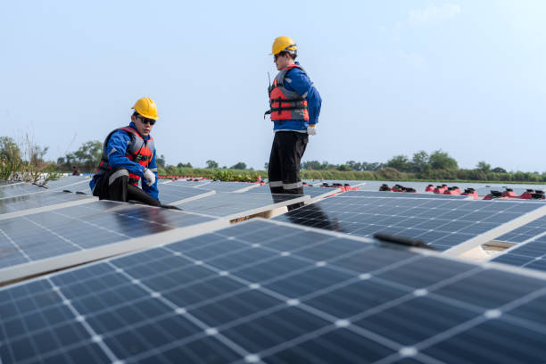 istock Male workers repair Floating solar panels on water lake. Engineers construct on site Floating solar panels at sun light. clean energy for future living. Industrial Renewable energy of green power. 2183165867