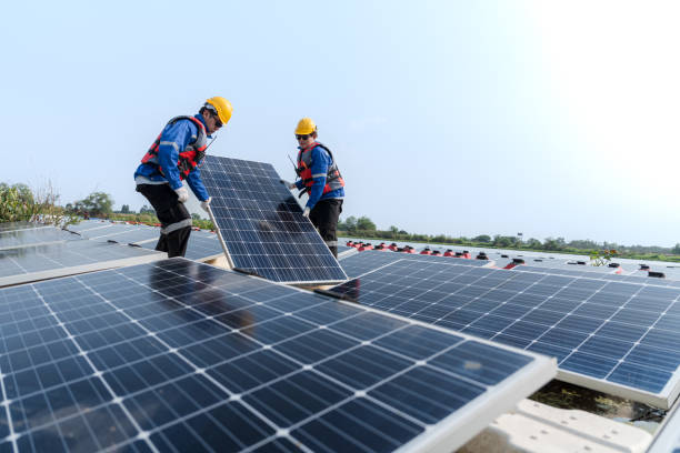 istock Male workers repair Floating solar panels on water lake. Engineers construct on site Floating solar panels at sun light. clean energy for future living. Industrial Renewable energy of green power. 2183166041