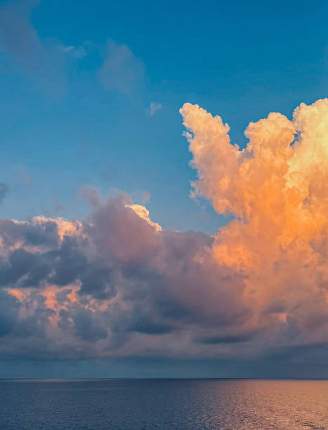 istock Bright orange and dark gray clouds over blue ocean 2183167347