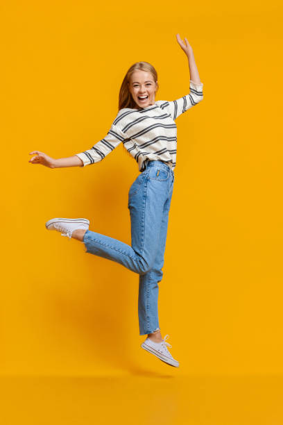 istock Teen girl having fun, jumping on orange studio background 2183177338