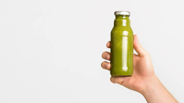 istock Female hand holding vegetable detox smoothie on white 2183178191