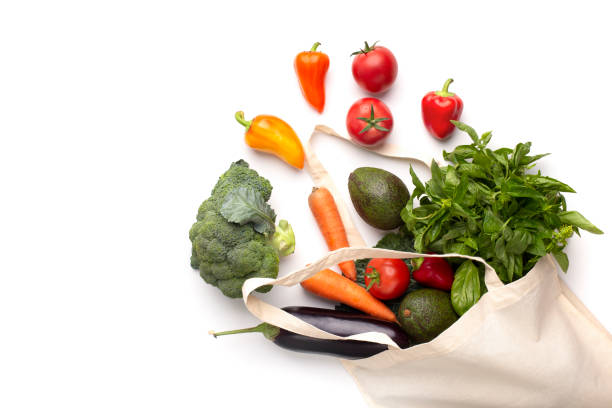 Concept of freshness. Colored organic vegetables in cotton shopping bag isolated on white background, copy space