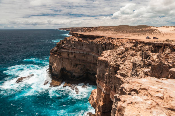 istock Waves crash against the rocky cliffs of Shark Bay while the bright sky reflects above 2183187693