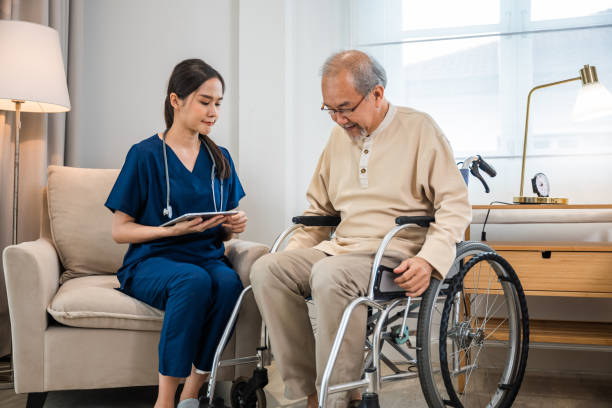 istock Asian woman doctor nursing holding digital tablet with patients chart while talking and explain for results of treatment to patient old man sitting in wheelchair 2183190000