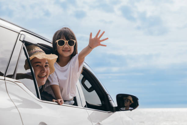 istock Father, mother and child smiling having fun sitting in compact white car windows raise hand wave bye bye 2183190093