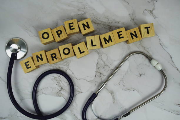 istock Open Enrollment with wooden blocks alphabet letters and stethoscope on marble background 2183198771