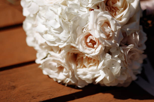 istock A wedding bouquet of white flowers sits on a wooden table 2183200631