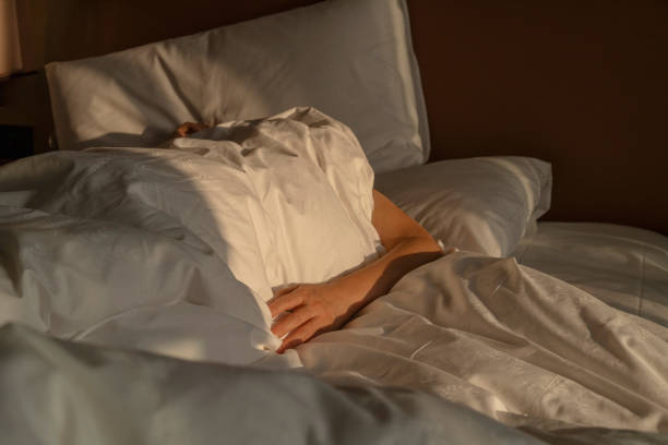 istock woman lying on bed in the dawn sunlight 2183202780