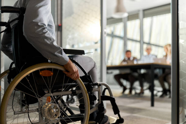 istock Unrecognizable candidate in a wheelchair entering on a job interview. 2183213796