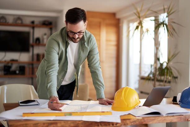 istock Male architect working on blueprints at home office. 2183215547