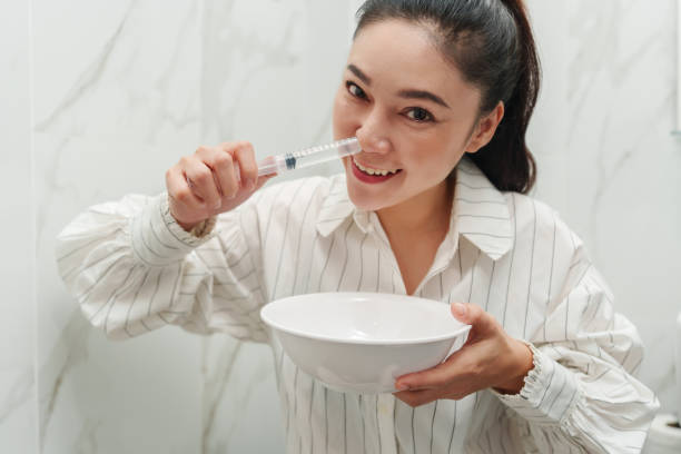 woman making nasal wash with using sryinge flushing inside nose
